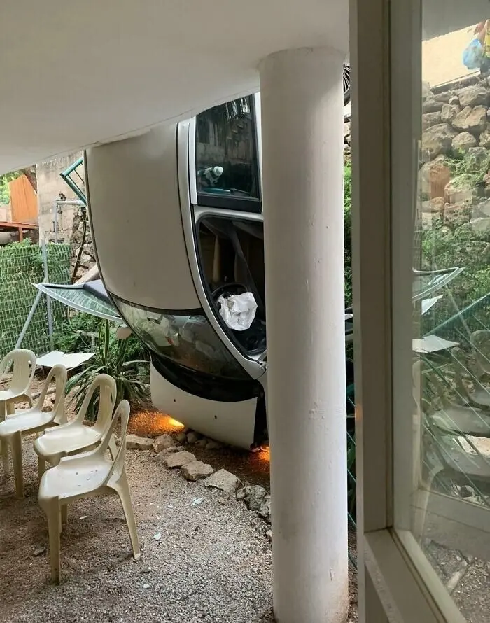 Машина, висящая на дереве над стульями